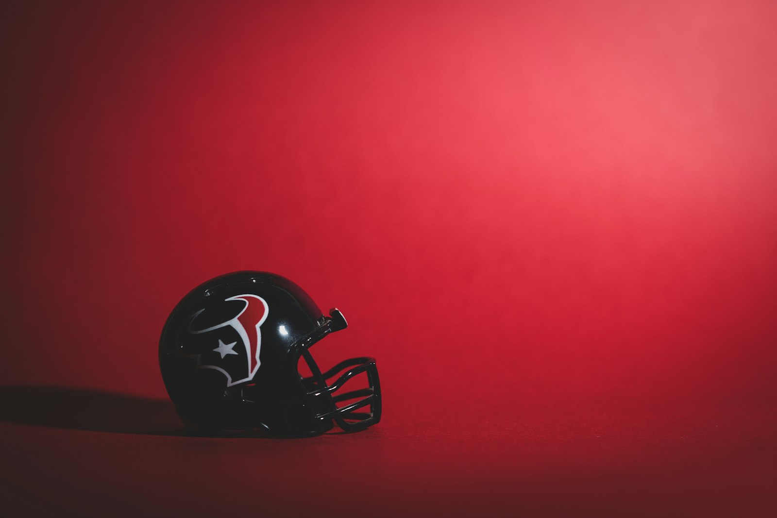 Black and red American football helmet with a metal facemask